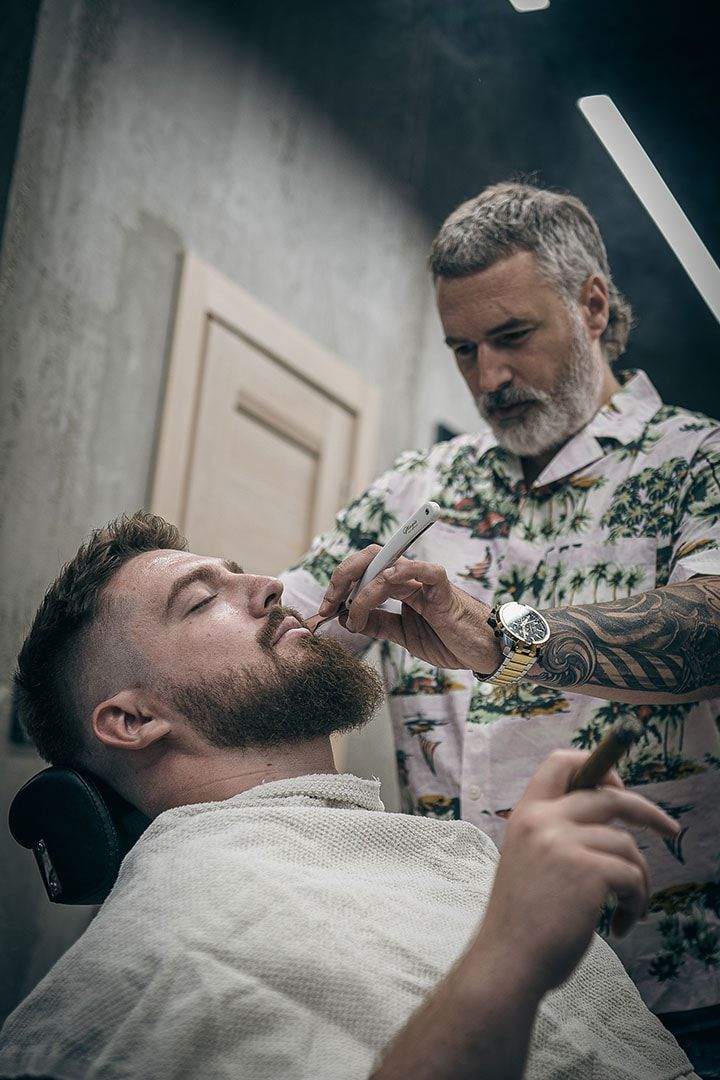 Ivan Bajić brije klijenta britvom u svom barber shopu