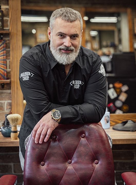 Ivan Bajić u barber shopu, naslonjen na klasičnu barbersku stolicu
