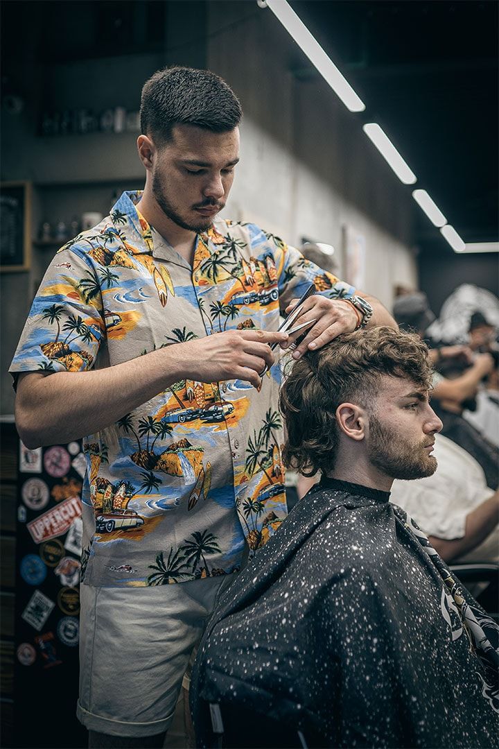 Barber radi fade tehniku makazama i češljem na klijentu